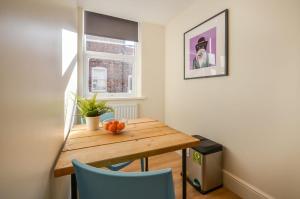 a small dining room with a wooden table and blue chairs at The Birchover Residences Trent Bridge in Nottingham