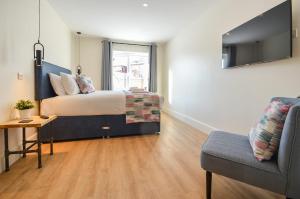 a bedroom with a bed and a couch and a chair at The Birchover Residences Trent Bridge in Nottingham