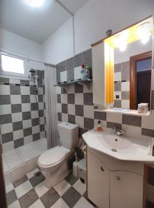 a bathroom with a toilet and a sink and a tub at Vanna's Holiday House in Ierissos