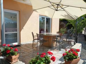 un patio avec une table, des chaises et un parasol dans l'établissement SEA & HONEY, à Krk