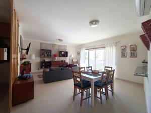 una cucina e un soggiorno con tavolo e sedie di Royal Cabanas Beach by Amandio Batista a Cabanas de Tavira Altre 2 foto