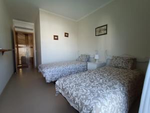 una camera con due letti e una porta per una stanza di Royal Cabanas Beach by Amandio Batista a Cabanas de Tavira