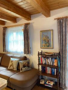 een woonkamer met een bank en een boekenplank bij Ferienhaus im Waldferiendorf Regen in Regen