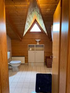 a bathroom with a toilet in a wooden ceiling at Ferienhaus im Waldferiendorf Regen in Regen