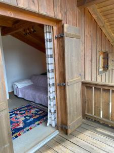 a small bedroom with a bed in a room with wooden walls at Ferienhaus im Waldferiendorf Regen in Regen