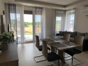 ein Esszimmer und ein Wohnzimmer mit einem Tisch und Stühlen in der Unterkunft Orchidea Apartmanház Egerszalók in Egerszalók