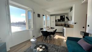 a living room with a couch and a table and a kitchen at Face au Vieux Port Vue 180 de Notre Dame au Panier in Marseille