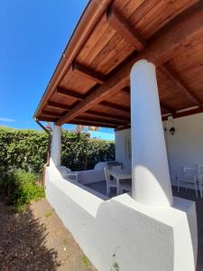 a white house with a wooden roof and a patio at Residence I Pagghiari Bungalow in Vulcano