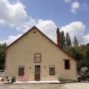 Gîte entre Loire et Campagne في Saint-Martin-sur-Ocre: منزل امامه كرسيين احمر