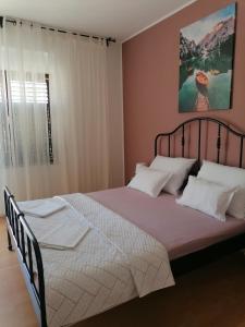 una camera da letto con un grande letto con cuscini bianchi di Apartments NIKA a Vodice