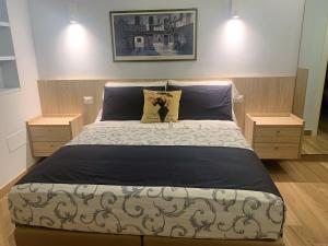 1 dormitorio con 1 cama grande y 2 mesitas de noche en Guest House Vagamondo, en Fano