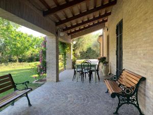 un patio con bancos, mesa y sillas en Guest House Vagamondo en Fano