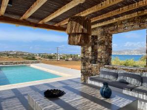 a patio with a couch and a swimming pool at Levantes Villa Panagia beach in Antiparos