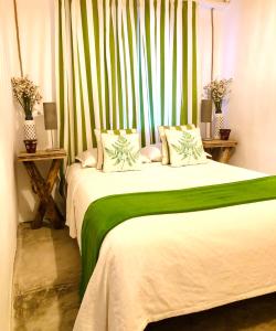 a bedroom with a large bed with green and white sheets at Casas das Piçarras - Alentejo in Piçarra +68 photos