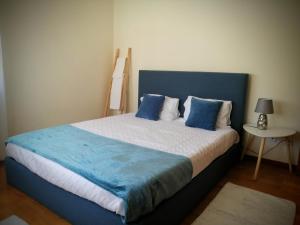 Un dormitorio con una cama grande con almohadas azules. en Casa Avó Rosa, en Nazaré