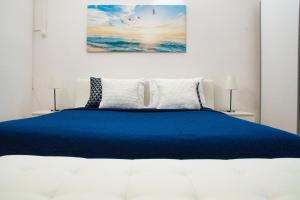 a bedroom with a blue bed with two lamps at White Orchid Pula in Pula