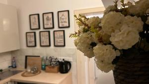 un vase rempli de fleurs blanches dans une cuisine dans l'établissement Designerwohnung Afrika sehr zentral gelegen, à Hanovre