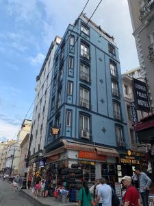 ein hohes blaues Gebäude in einer Stadtstraße mit Menschen in der Unterkunft Gulhane Corner Hotel in Istanbul