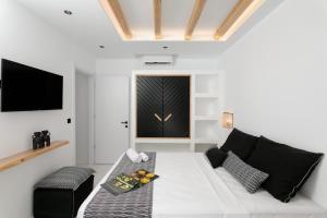 a living room with a white couch and a tv at Naxos White Concept in Naxos Chora