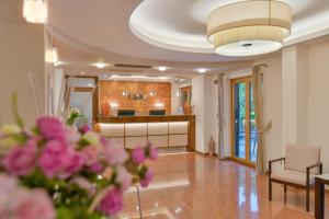ein Wohnzimmer mit rosa Blumen und eine Küche in der Unterkunft Hotel Mareluna in Castellabate