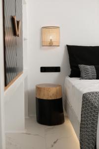 a bedroom with a bed with a table next to it at Naxos White Concept in Naxos Chora