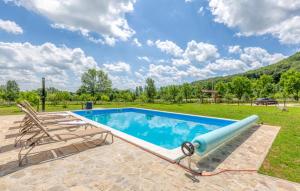 a swimming pool with a couple of chairs next to it at Manuela in Gospić