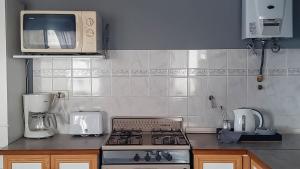a kitchen with a stove and a microwave at La huerta in Ushuaia +5 photos