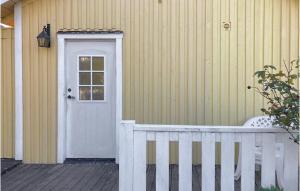 une maison avec une porte blanche et une clôture blanche dans l'établissement Lovely Home In Mrbylnga With Kitchen, à Mörbylånga