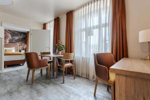 a hotel room with a table and chairs and a bed at Hotel & Restaurant Rödersaal in Großröhrsdorf