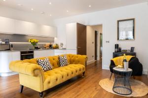 a living room with a yellow couch and a kitchen at Springfield Thirteen in Harrogate