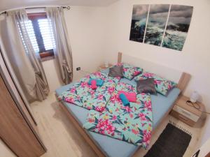 a bedroom with a blue bed with flowers on it at Haus Cataleya in Umag