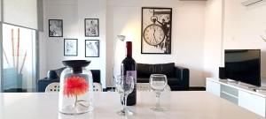 uma garrafa de vinho e dois copos de vinho numa mesa em Dezo Luxury town Apartment em Lárnaca