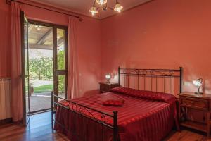 a bedroom with a bed with a red bedspread at Agriturismo Le Dolci Colline in Valfabbrica