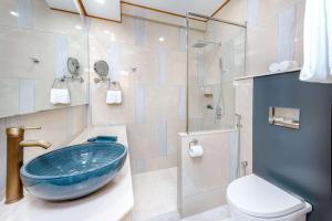 a bathroom with a blue bowl sink and a toilet at Marukab Plaza in Male City