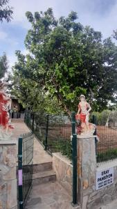 una estatua de una mujer junto a una valla en ERAY PANSİYON, en Gokceada Town