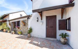 uma casa branca com uma porta castanha e vasos de plantas em 2 Bedroom Gorgeous Home In Motta San Giovanni em Motta San Giovanni