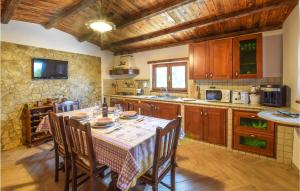 uma cozinha com mesa e cadeiras e uma cozinha com armários de madeira em 2 Bedroom Gorgeous Home In Motta San Giovanni em Motta San Giovanni