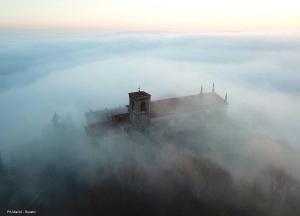 un edificio en la niebla con una cruz encima en Annunciata Soul Retreat, en Coccaglio