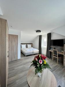 a living room with a vase of flowers on a table at Hotel Ocean in Norddeich +64 photos