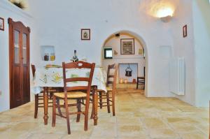 a kitchen and dining room with a table and chairs at Trulli Vulés in Ostuni