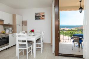 uma cozinha com mesa e cadeiras e uma varanda em Apartments Otia Seaview em Porat