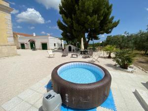 a swimming pool with a wicker tub in a yard at Casale Montereale in Corato