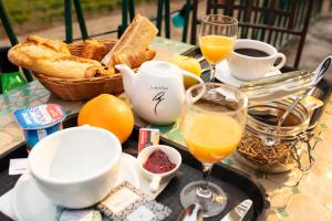 una mesa con una bandeja de alimentos y bebidas para el desayuno en Hotel Les Rocailles, en Montagnac