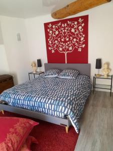 ein Schlafzimmer mit einem Bett und einer rot-weißen Wand in der Unterkunft Tour médiévale de l'an mille in Loudes