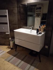 bagno con lavandino bianco e specchio di Tour médiévale de l'an mille a Loudes