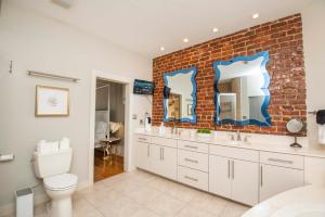 a bathroom with two sinks and a brick wall at Largest Rooftop w Firepit - Vaulted LUXE Penthouse in Knoxville