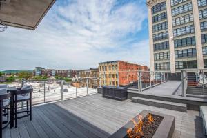 a rooftop deck with a fire pit and buildings at Largest Rooftop w Firepit - Vaulted LUXE Penthouse in Knoxville