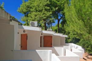 a white house with brown doors and trees at Hotel Kyrie Isole Tremiti in San Domino