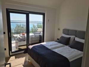 沃希Appartments Akrapovic的一间带大床的卧室和一个阳台