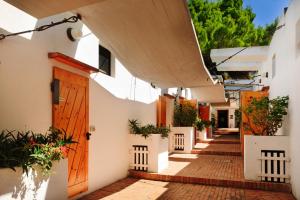 an alley with white buildings and a wooden door at Hotel Kyrie Isole Tremiti in San Domino